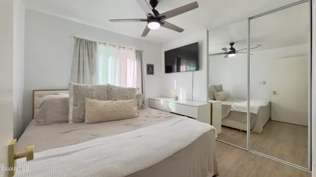 a bedroom with a large bed a chandelier and a window