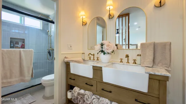 a bathroom with a double vanity sink toilet and shower