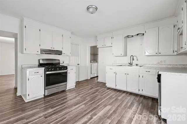 a kitchen with granite countertop a sink cabinets and stainless steel appliances