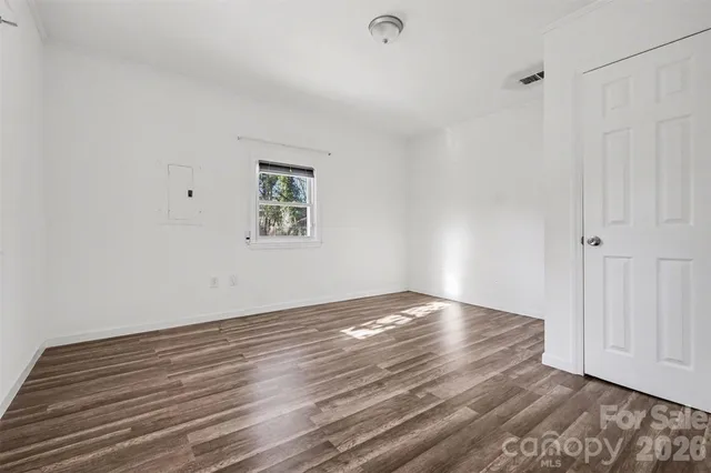 a view of an empty room with wooden floor