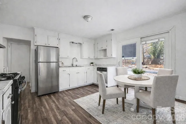 a kitchen with refrigerator a sink and chairs