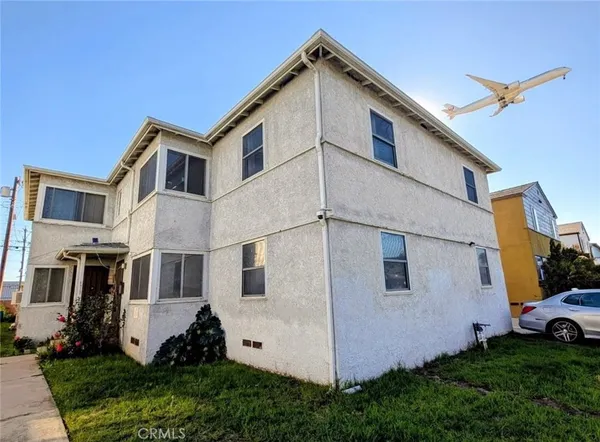 a view of a white house with yard and plants