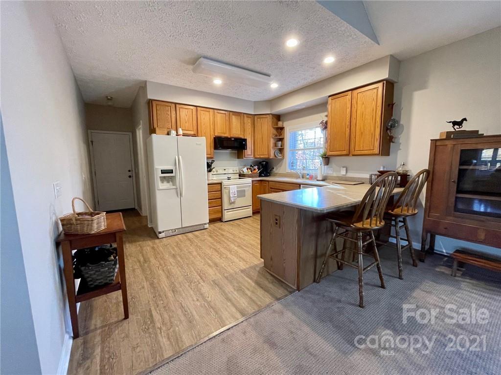 85 Moore Road Tryon, NC 28782 - Photo 7 of 20 a kitchen with stainless steel appliances kitchen island granite countertop a table chairs sink and cabinets