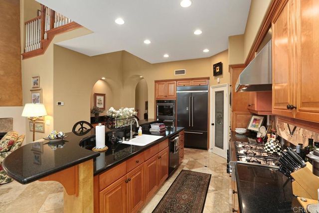 a large kitchen with a large counter top appliances and cabinets