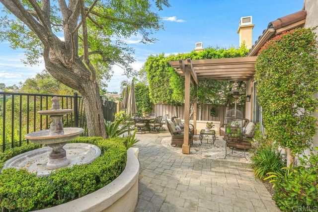 a view of a patio with table and chairs potted plants and large tree