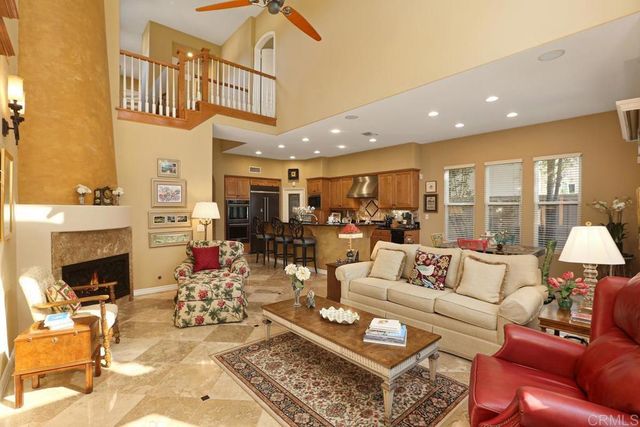 a living room with furniture a fireplace and a chandelier