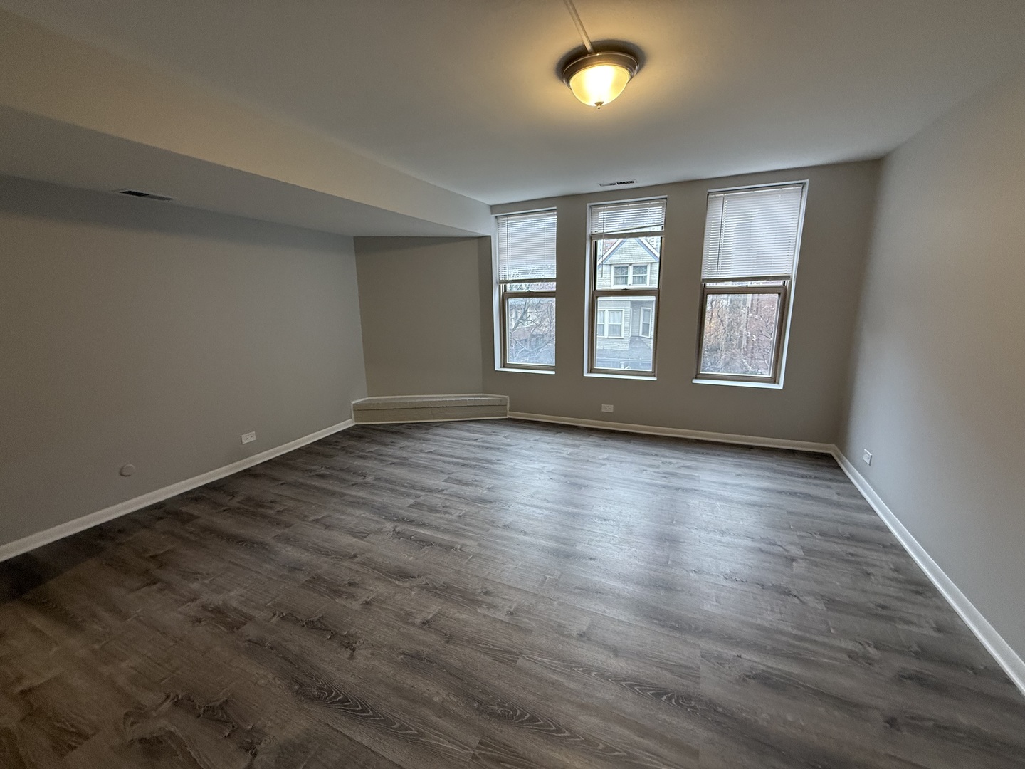 744 West Gordon Terrace, Unit 304 Chicago, IL 60613 - Photo 3 of 12 an empty room with wooden floor and windows