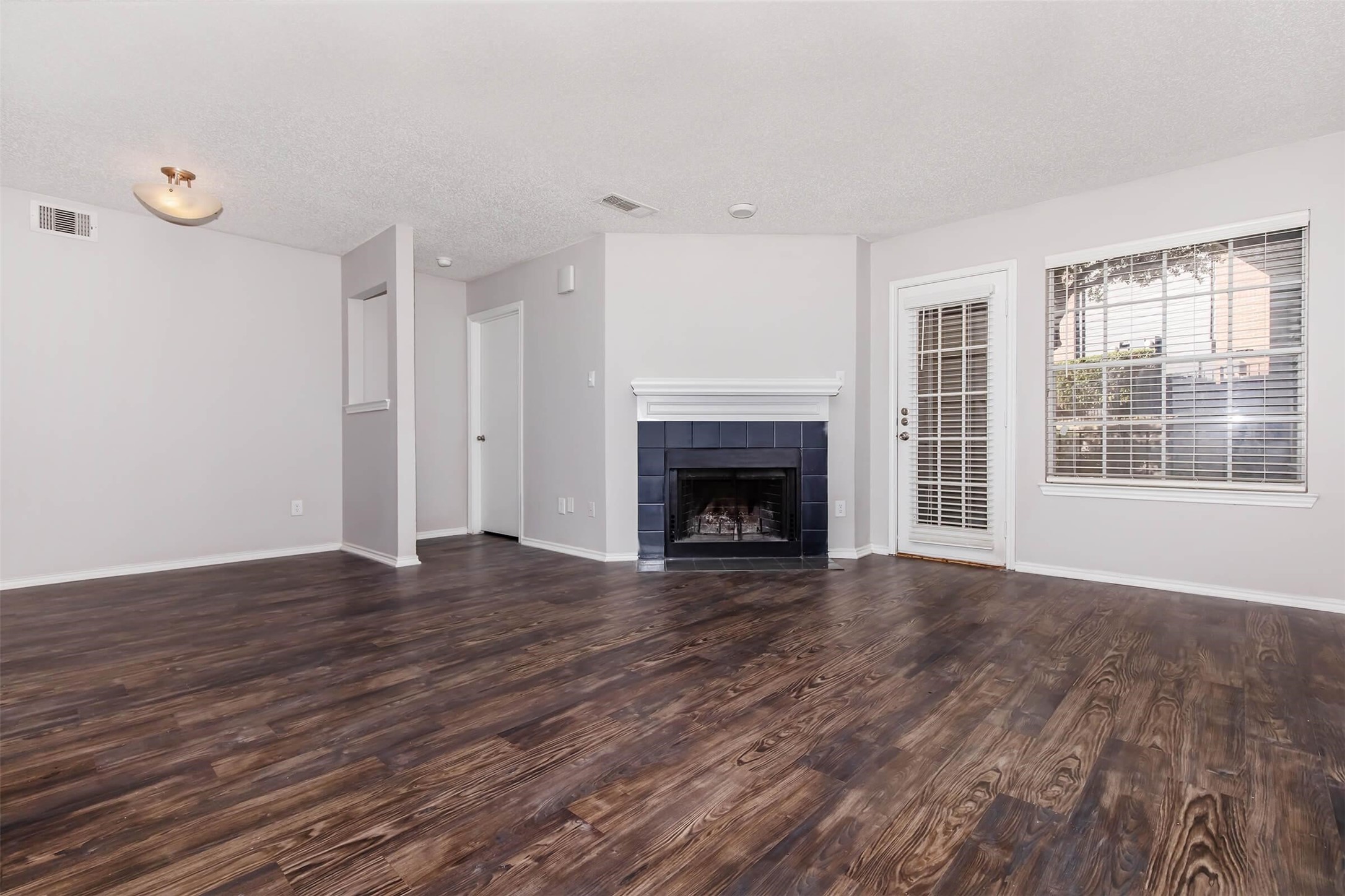 8301 Boat Club Road, Unit 1214 Fort Worth, TX 76179 - Photo 2 of 44 an empty room with wooden floor fireplace and windows