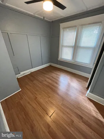 a view of empty room with window and wooden floor