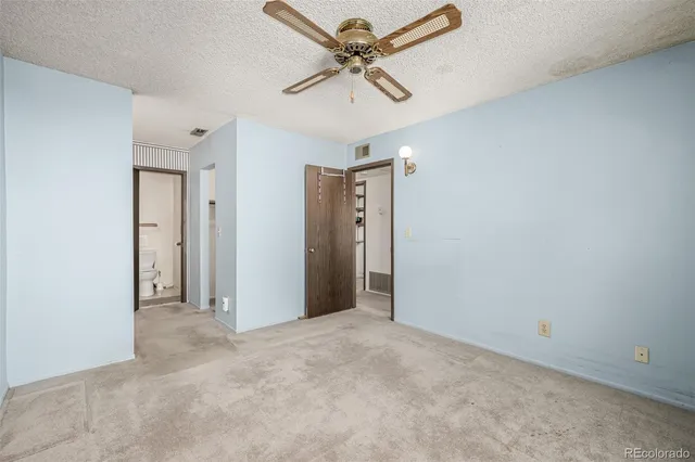 an empty room with a ceiling fan and window