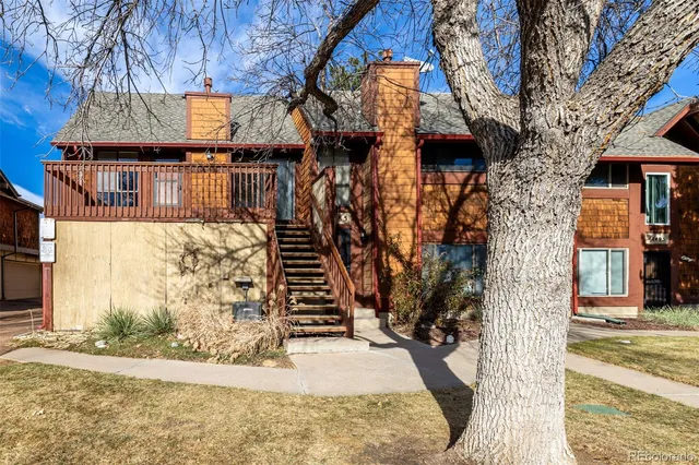 a front view of a house with a tree