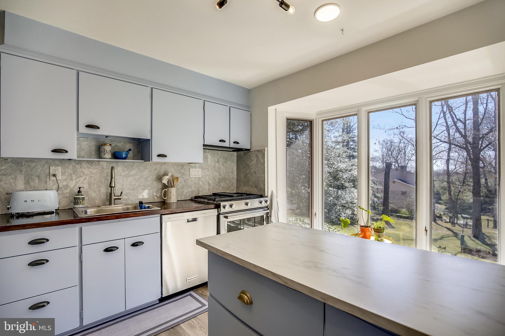 400 Stonington Road Silver Spring, MD 20902 - Photo 10 of 66 a kitchen with stainless steel appliances a sink a stove and white cabinets