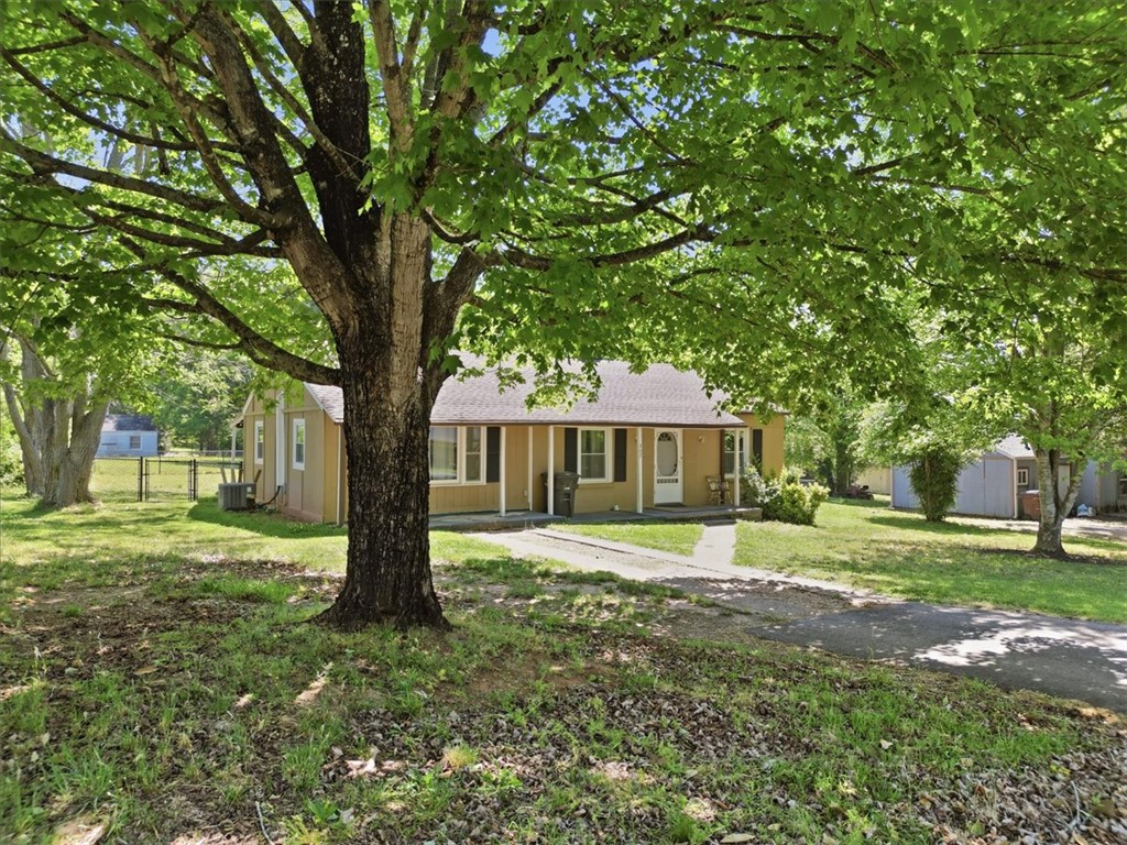 307 South Elm Street Pendleton, SC 29670 - Photo 4 of 41 Charming home nestled under mature trees, offering a serene and welcoming curb appeal.
