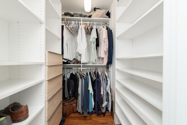 a view of walk in closet with clothes and shoes