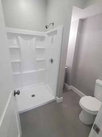 a bathroom with a toilet and a shower