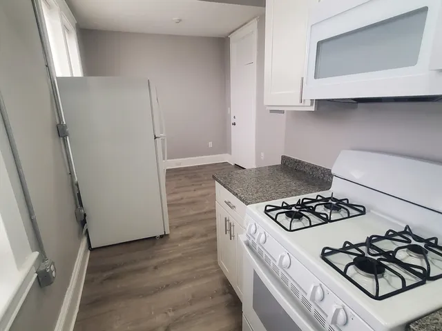 a kitchen with granite countertop a stove and a refrigerator