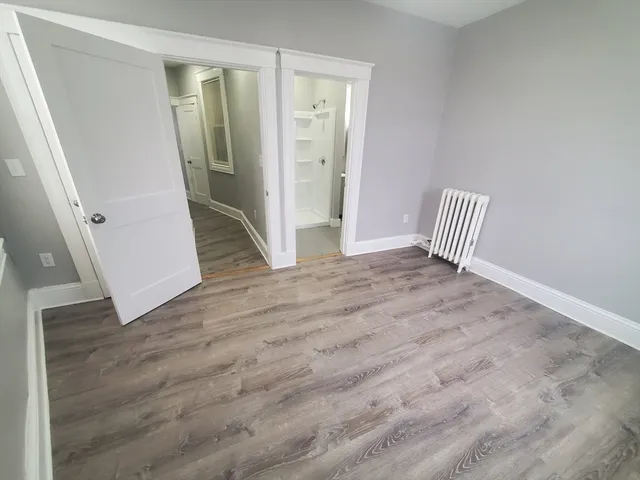 a view of empty room with wooden floor