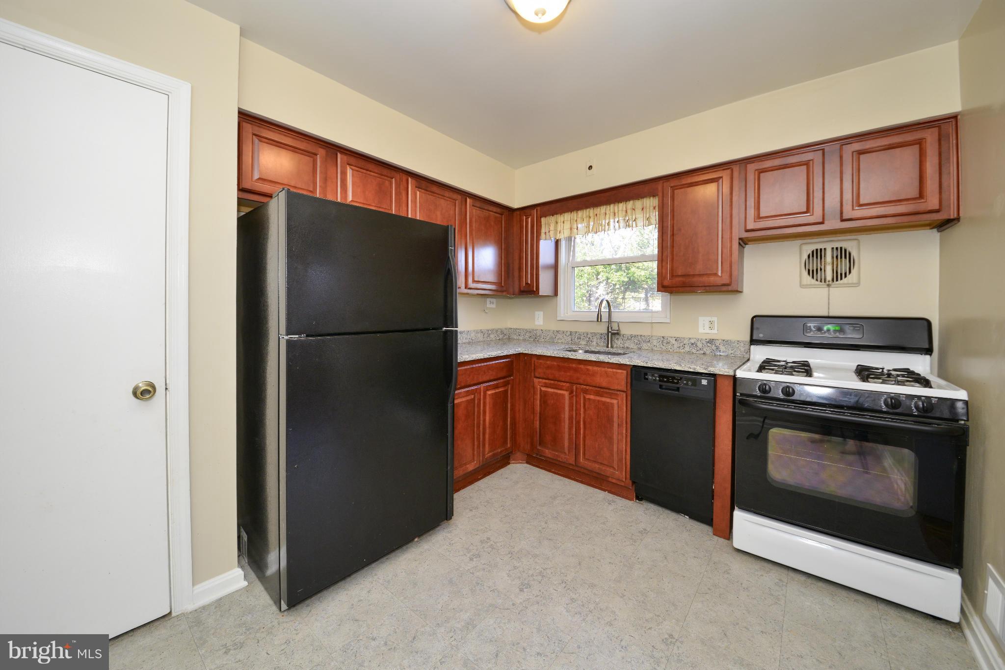 6902 Highland Street Springfield, VA 22150 - Photo 8 of 24 a kitchen with stainless steel appliances granite countertop a refrigerator stove and sink