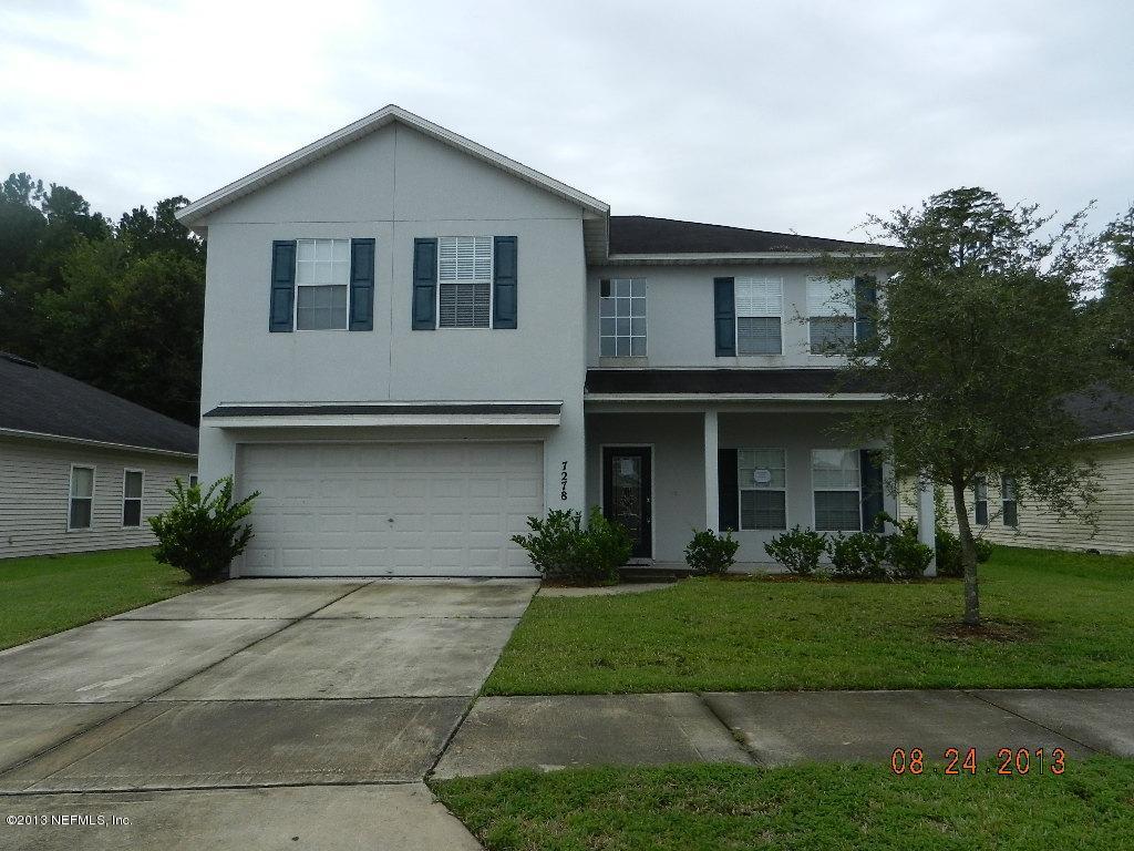 7278 Rampart Ridge Circle South Jacksonville, FL 32244 - Photo 1 of 14 a front view of a house with a garden and trees