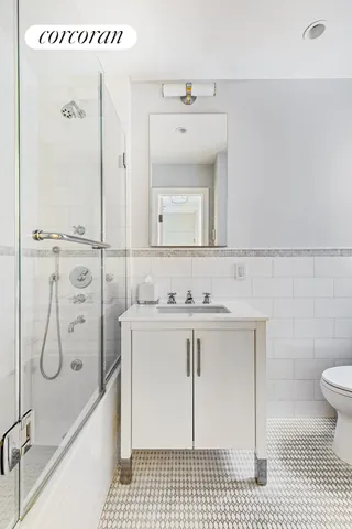 a bathroom with a sink toilet vanity and shower