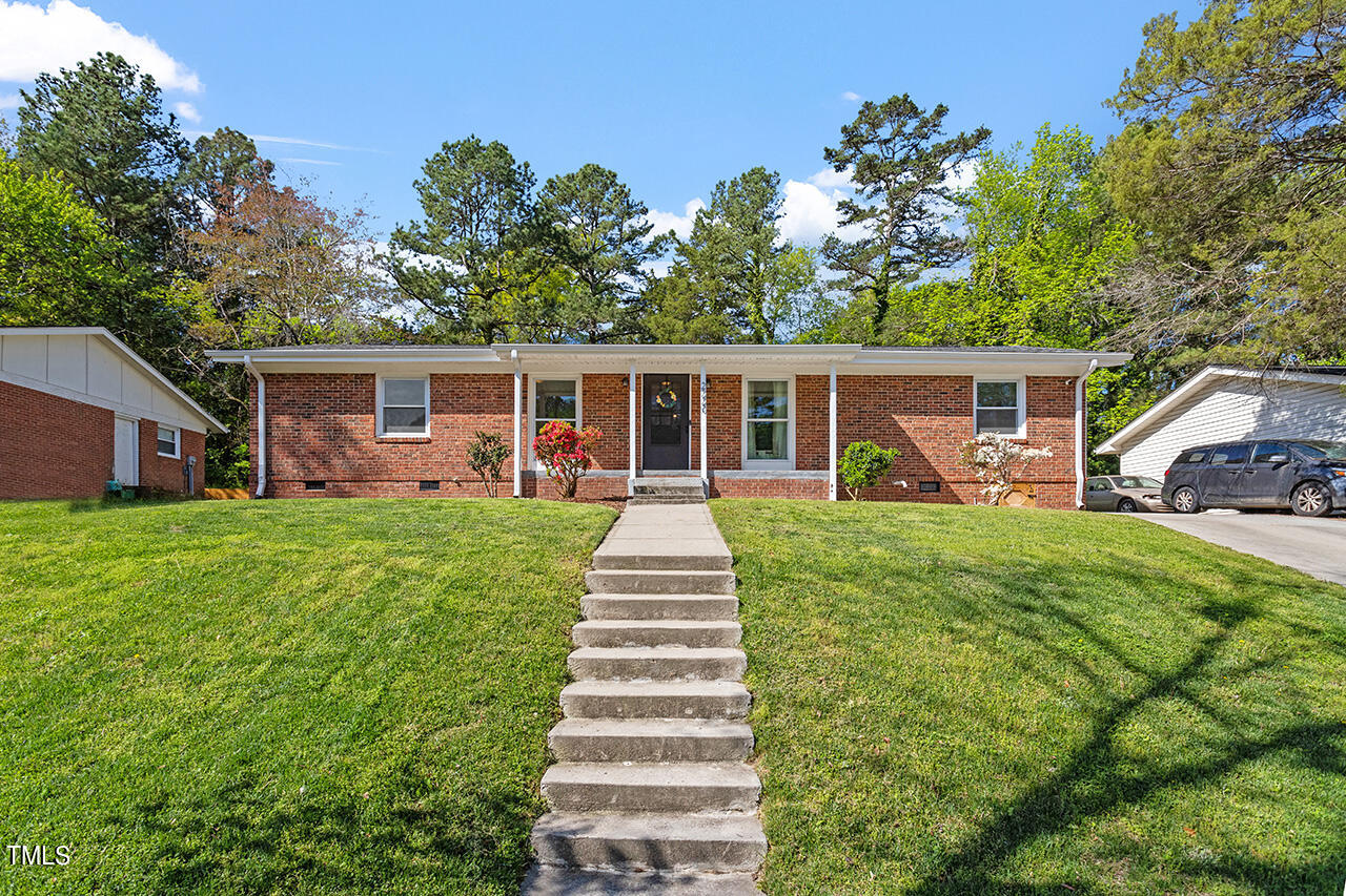 2220 Foxtrot Road Raleigh, NC 27610 - Photo 1 of 24 a front view of a house with a yard table and chairs