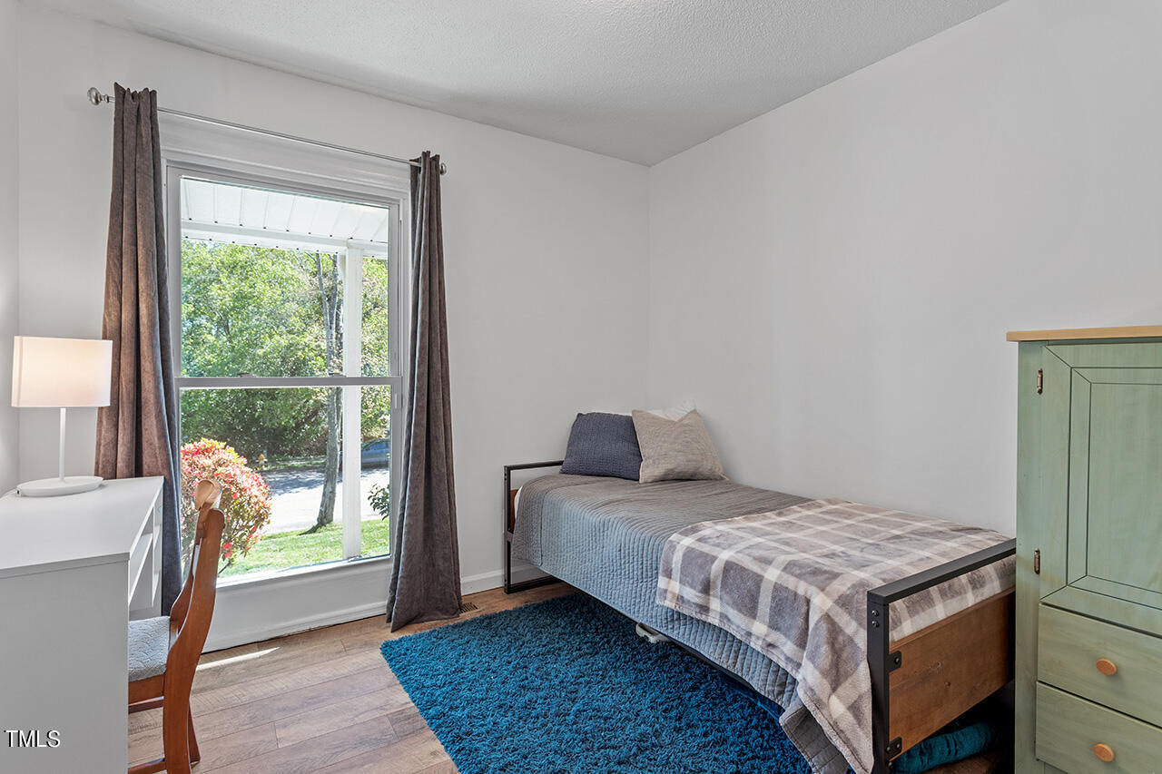 2220 Foxtrot Road Raleigh, NC 27610 - Photo 18 of 24 a bedroom with a bed and wooden floor
