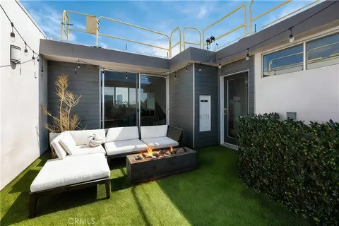 a view of a patio with couches table and chairs and potted plants
