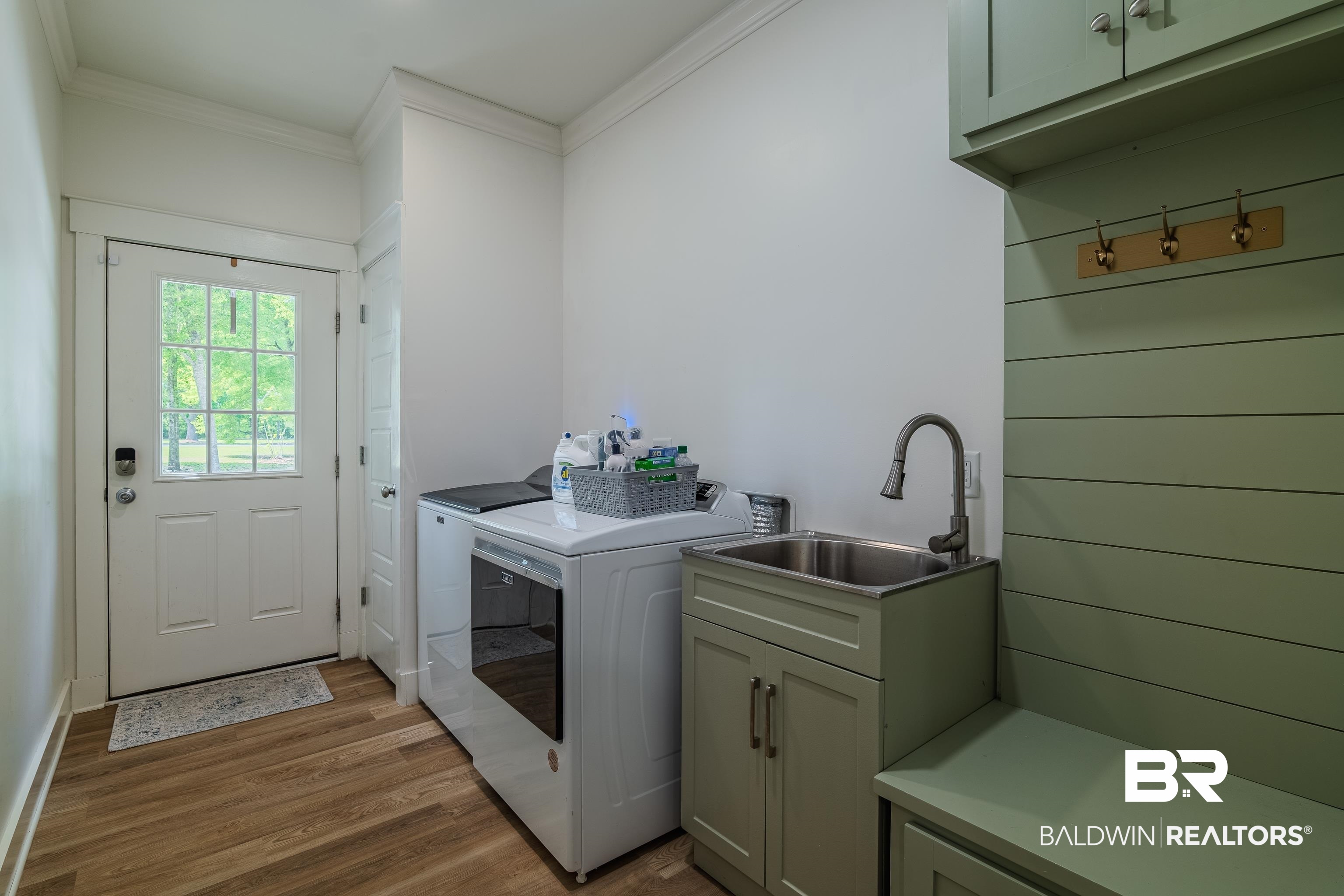 19121 Boothe Road Fairhope, AL 36532 - Photo 24 of 41 Laundry area with cabinet space, dark wood finished floors, washing machine and clothes dryer, and ornamental molding