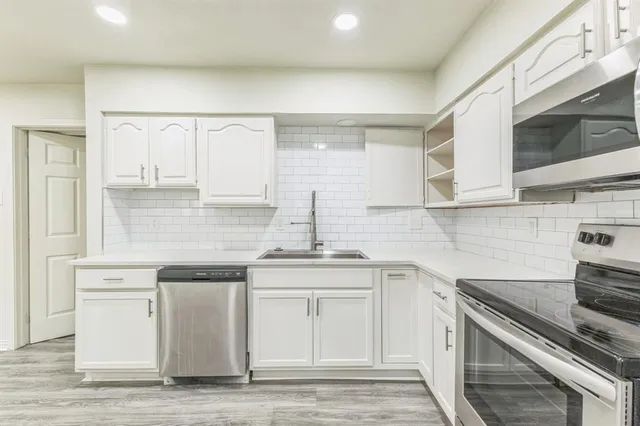 a kitchen with stainless steel appliances white cabinets and a sink
