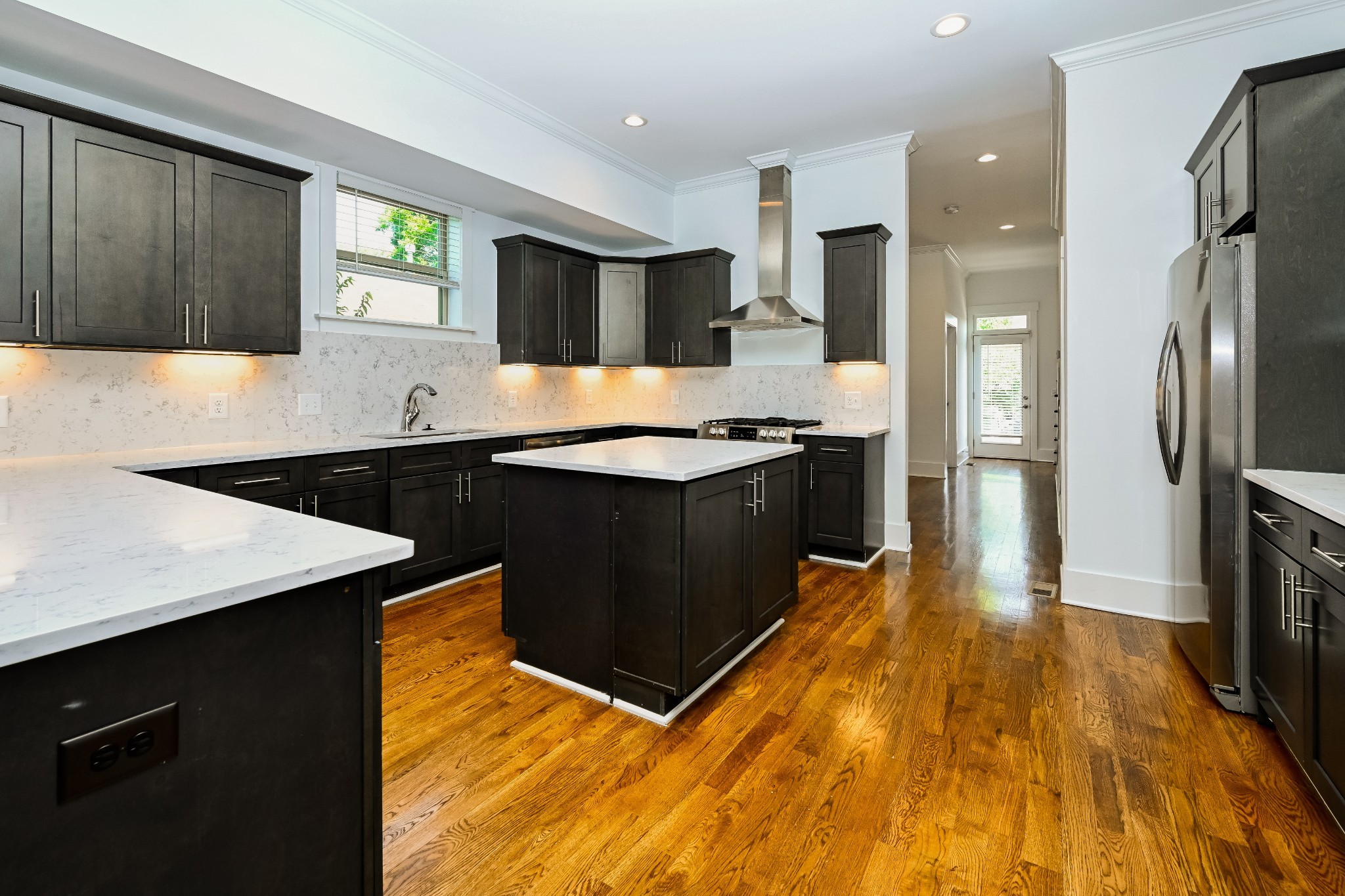341 Edwin Street, Unit B Nashville, TN 37207 - Photo 2 of 17 a kitchen with stainless steel appliances kitchen island a sink dishwasher a refrigerator and a stove with wooden floor