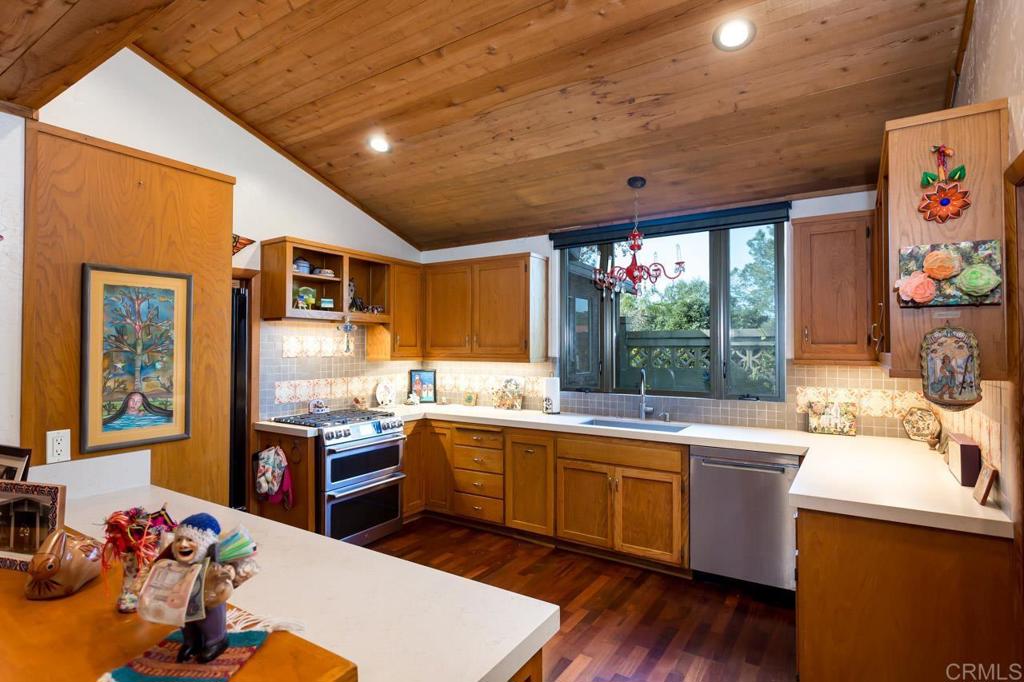 1249 Melba Road Encinitas, CA 92024 - Photo 19 of 47 a open kitchen with stainless steel appliances granite countertop a sink dishwasher stove and wooden cabinets with wooden floor