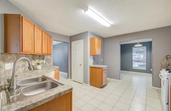 a kitchen with granite countertop a sink and a stove top oven
