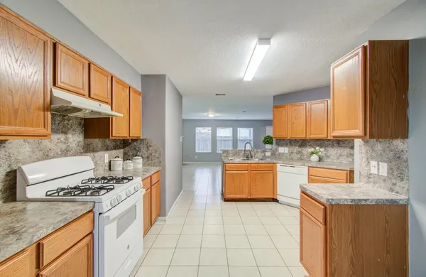 a kitchen with stainless steel appliances granite countertop a stove a sink and a microwave