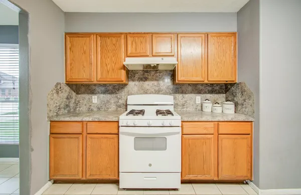 a kitchen with a stove sink and cabinets