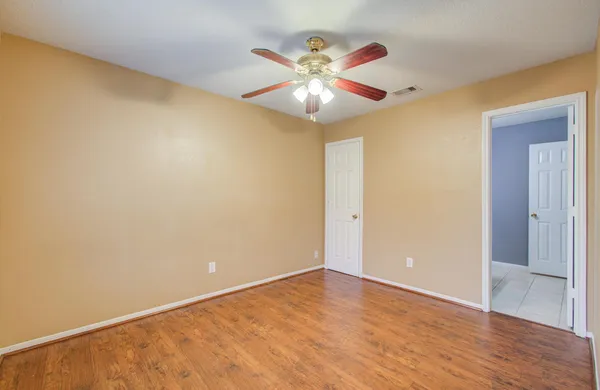 a view of an empty room with wooden floor