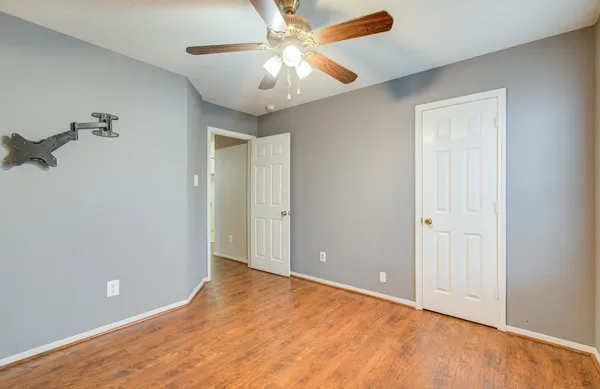 an empty room with closet and a chandelier fan