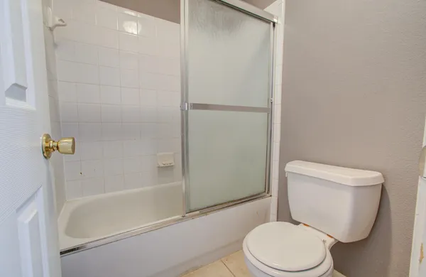 a white toilet sitting next to a bath tub