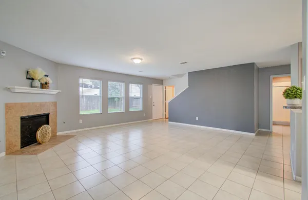 a view of an empty room with a fireplace and a window