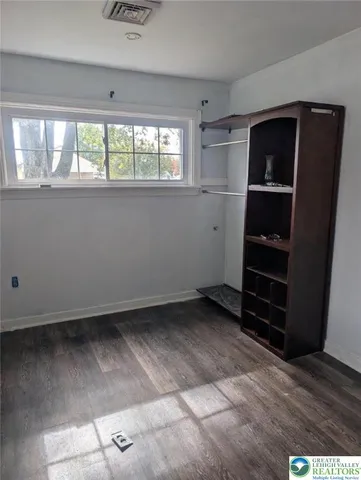a view of a workspace with wooden floor and a window