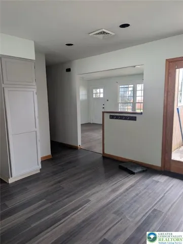an empty room with wooden floor and entrance