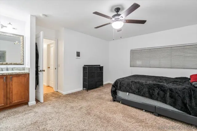 a bedroom with a bed and a ceiling fan