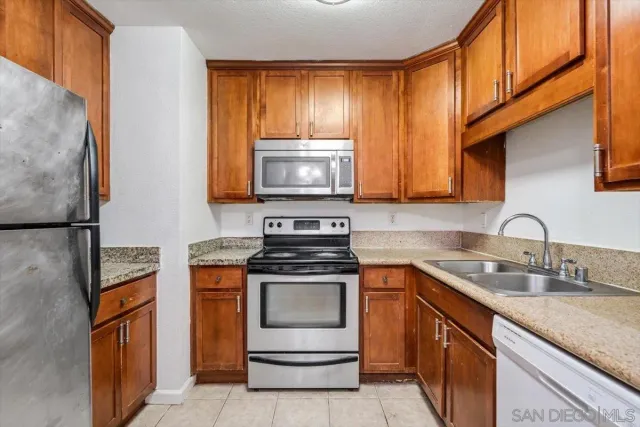 a kitchen with granite countertop cabinets stainless steel appliances and a sink