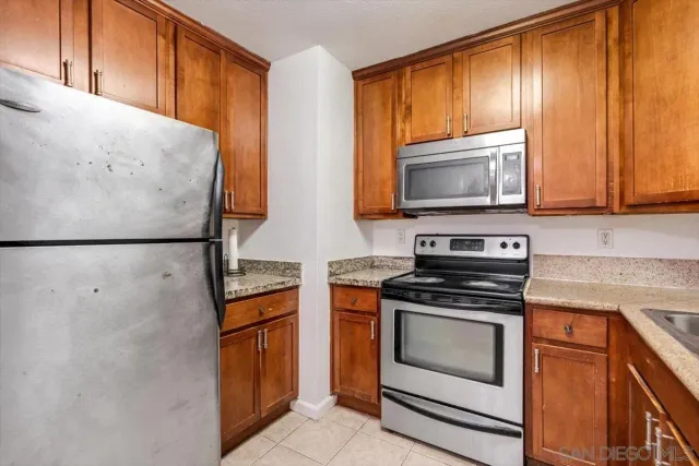 a kitchen with stainless steel appliances granite countertop wooden cabinets and a stove top oven