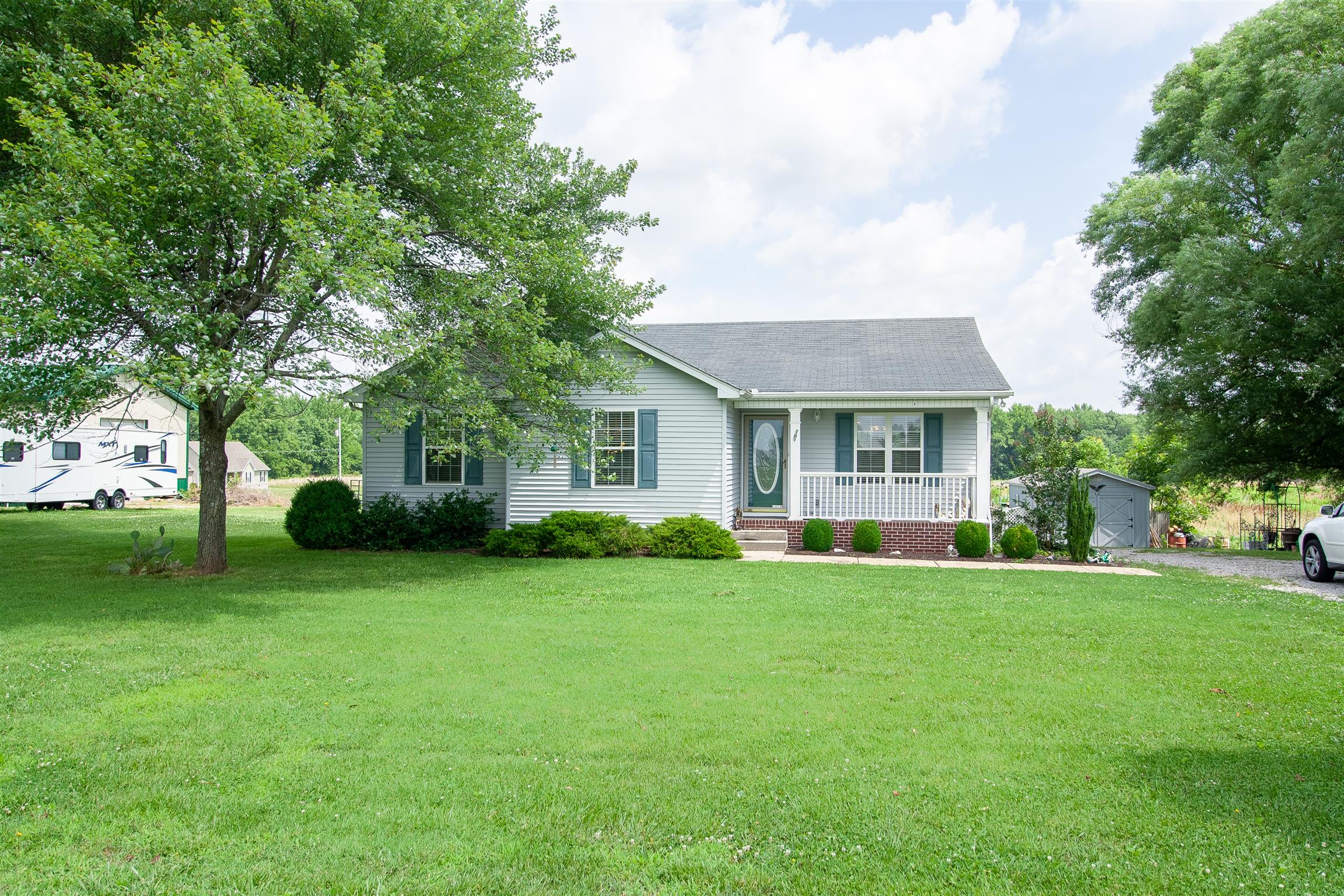 183 Shuab Road Portland, TN 37148 - Photo 1 of 25 a view of a house next to a big yard and large trees