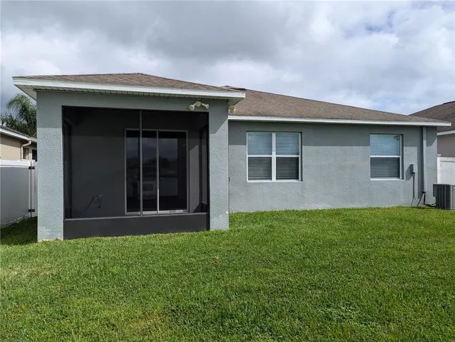 a view of front of a house with yard and large tree