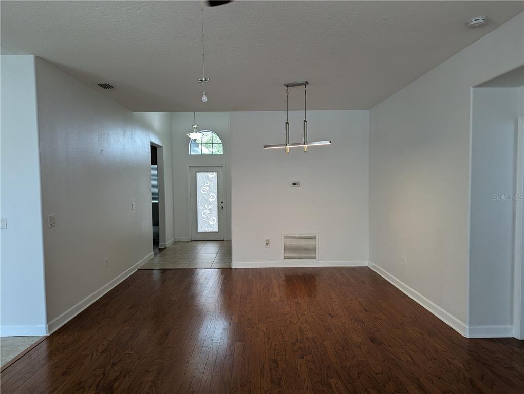13428 Graham Yarden Drive Riverview, FL 33579 - Photo 2 of 15 an empty room with wooden floor and a hallway