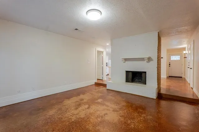 an empty room with wooden floor and fireplace