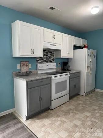 a kitchen with white cabinets and white appliances