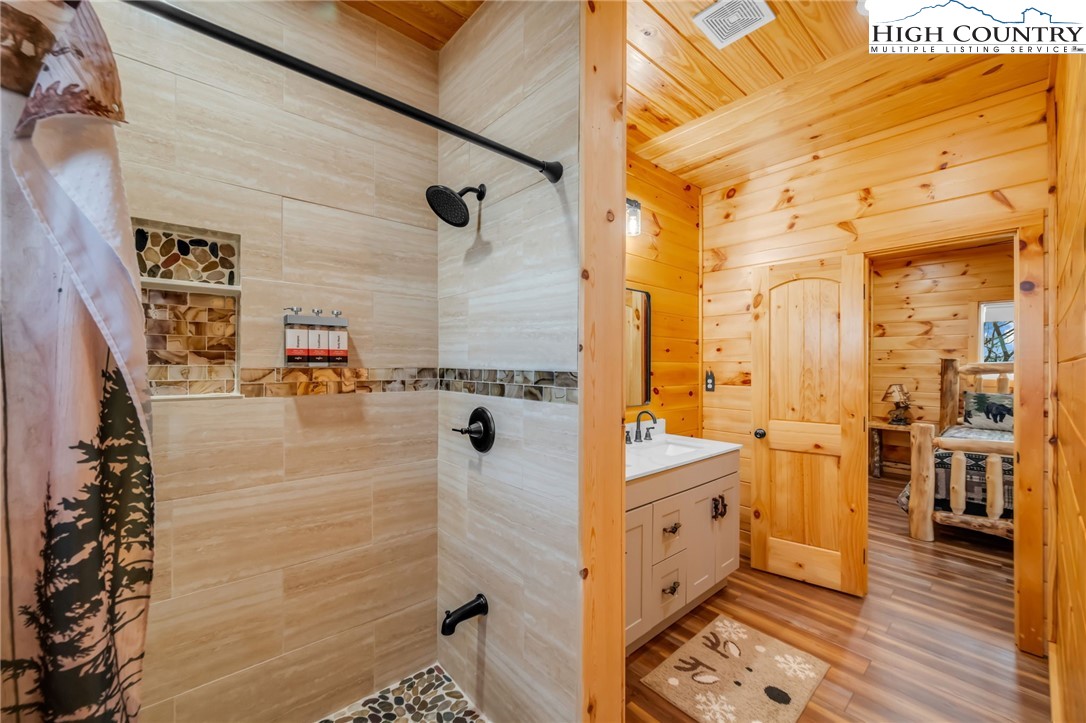 2533 Buck Mountain Road Purlear, NC 28665 - Photo 33 of 40 a bathroom with a tub shower and a sink
