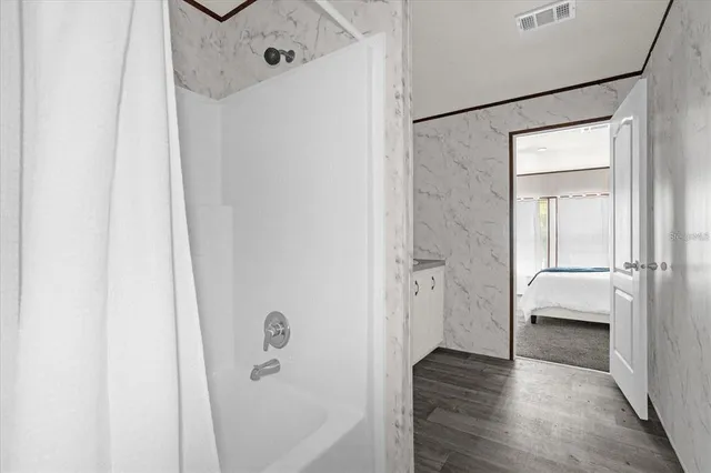 a view of a hallway with wooden floor and closet
